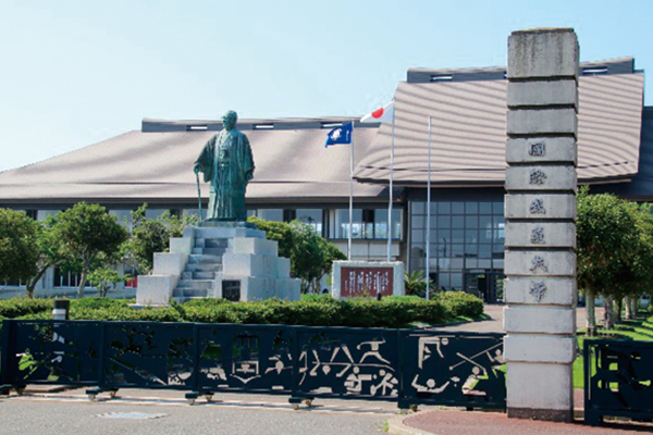 大学正門と松前重義博士像